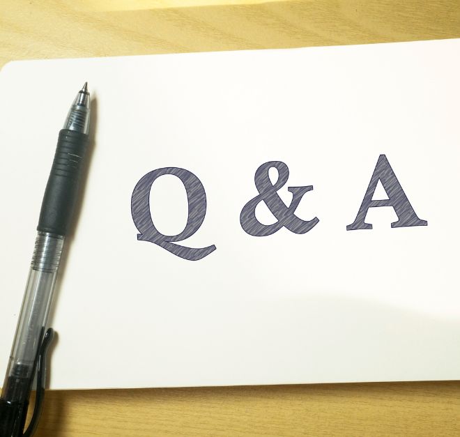 A pad of paper with Q&A written on it and a black pen laying beside the letters