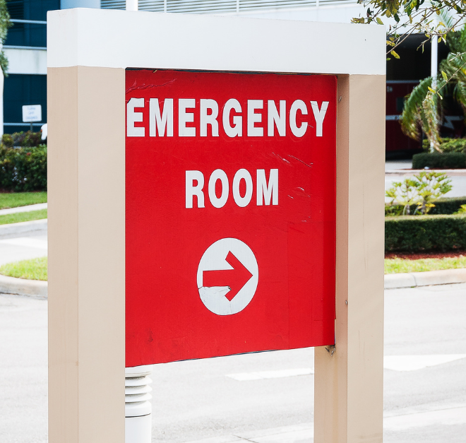 Red and white EMERGENCY ROOM sign with arrow pointing right